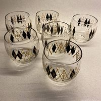 Six lowball glasses arranged in two rows showcasing the black and gold diamond pattern on each glass.