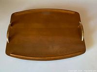 Top-down view of the maple wood serving tray showing the rectangular shape and brass handles.