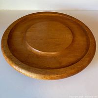 Top view of vintage solid hardwood lazy Susan showing natural wood grain, circular indentation along rim, and raised center section.