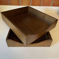 Two wooden rectangular in/out boxes stacked on each other, showing half-moon access notch on one side, medium brown wood finish.
