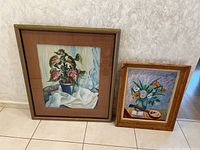 Both paintings shown side by side on floor against wall, showing relative sizes and frames with wear