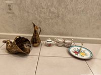 Full set of Stangl Pottery pieces arranged in a row on floor: cornucopia, pitcher, sugar bowl, four coffee cups, serving tray.