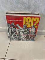 Stack of vinyl records with Tchaikovsky's 1812 Overture as the front album with red cover and historical soldier illustration.