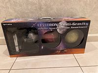 Original box of Levitron Anti-Gravity Deluxe Space Mission Assortment showing packaging with visible globes of Earth, Mars, and Moon.