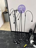 Cluster of nine black gooseneck LED lights with round bases arranged upright.