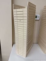 Stack of cream colored storage bins/cubbies against a wall, stacked vertically showing size and quantity.