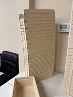 Stack of cream-colored plastic storage bins showing height and tapered sides.