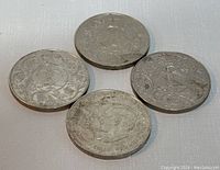 Three silver-coloured coins featuring crowned bird and foliage designs on one side plus dual portraits of George VI and Queen Elizabeth on another one.