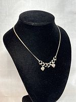 Front view of the 15 inch silver necklace displayed on black velvet bust, showing linked bead design and two heart-shaped pendants.