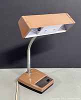 Front side view of vintage adjustable goose neck desk lamp showing beige rectangular shade and base with chrome neck and power switch.