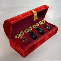 Set of four miniature perfume bottles in original red velvet box, showing arrangement and box condition.