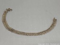 Full view of the silver anklet showing the overall linked design and clasp end.