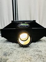 Front view of projector showing lens and ArtoGraph Prism logo