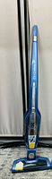 Front view of blue Electrolux cordless vacuum cleaner showing handle, control panel, and dust compartment.