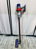 Full view of vacuum upright with wand and floor head against white background