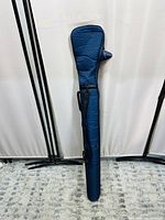 Front view of the padded blue modern style golf bag for golf clubs with handles and straps visible against a white background