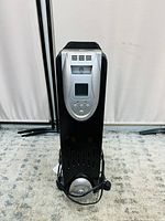 Front view of black oil filled radiator heater showing digital control panel and buttons