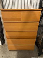 Front view of the 6 drawer wooden dresser showing light wood veneer and smooth flat drawer fronts.