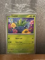 Photo of sealed Oddish Pokemon star card in plastic protective sleeve.