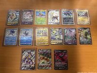 Photo showing 15 various Pokémon trading cards including holographic and foil cards.