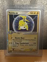 Front side of Raichu EX 2003 Pokémon card in protective sleeve showing artwork, HP, and attacks.