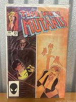 Front cover photo of The New Mutants #23 comic book in protective sleeve showing cover art, Marvel branding, price, and issue number.