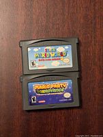 Top view showing front labels of two Game Boy Advance game cartridges: Super Mario World: Super Mario Advance 2 and Mario Party Advance.
