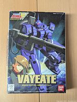Front of the Vayeate Gundam model kit box showing purple mobile suit illustration and branding.