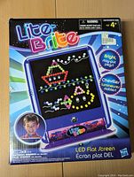 Lite Brite LED flat screen toy in box with colorful pegs and example designs displayed