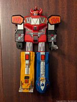 Front view of the 1993 Bandai Power Rangers Megazord figure showing red, yellow, blue, black and silver colors along with horned helmet and arm and leg detailing. The sword is visible in the right hand.