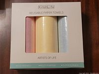 Front of the box showing three reusable paper towel rolls in pink, yellow, and blue, brand KitchLife, labeled Artists of Life