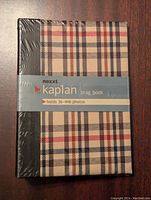 Front side of unopened Nexxt Kaplan small photobook in original plastic wrapping with plaid cover and label indicating capacity for 36 4x6 photos.