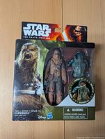 Star Wars The Force Awakens branded packaging showing Chewbacca figure with removable armor accessory inside sealed box.