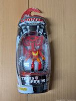 Front view of unopened Transformers Rodimus Prime action figure in Titanium Series packaging, featuring clear blister pack and character art.