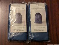 Two new navy blue mesh laundry bags in original packaging showing front label and drawstring cord lock.