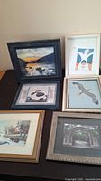 Framed artwork collection showing six different pieces with different themes and frame styles