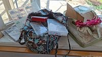Overview of fabric tote bag and storage boxes with beads inside on a window sill