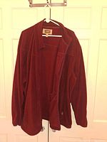 Full view of the burgundy lightweight jacket hanging on a hanger displaying front and open to inside.