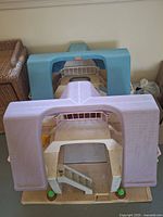 Two Lil Tykes playhouses, one blue and one lavender, shown from the back with visible wear and dirt.