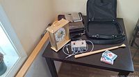 Photo showing all items on table including clock, leather organizer, laptop case, wooden backscratcher, and two decks of Bicycle playing cards.