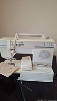 Front view of Singer electric sewing machine with pedal and instruction manual included