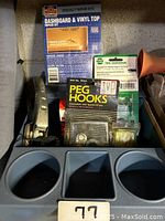 Blue plastic console organizer with multiple compartments, showing front view with cup holders and rectangular slot.