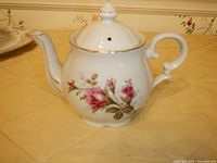 Homer Laughlin Eggshell Georgian ivory and gold teapot with rose floral design, showing side view.
