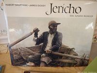 Cover of the large book "Jericho The South Beheld" showing a man in rustic attire with oars, by Hubert Shuptrine and James Dickey.