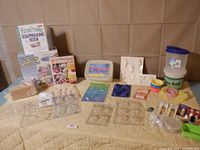 Full overview photo of all soap, candle, and plaster making supplies laid out on a quilted surface.