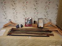Full lot view on table including belts laid out, handkerchiefs, shoe brushes, mitt cleaners, wooden hangers arranged on either side
