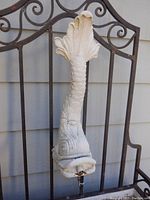 Close-up of the fish-shaped spout of the outdoor fountain, detailing the sculpted design and wear.