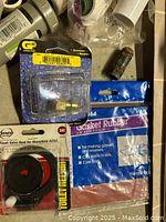 Close up photo showing gasket rubber package, flush valve for toilet tank, and other plumbing small parts.