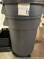 Close-up of a large 32-gallon Rubbermaid outdoor trashcan with lid.