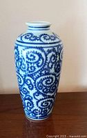 Front view of blue and white 1950s Chinese porcelain vase showing curled tendril decoration.